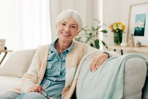 Life Assure Senior Woman Sitting In Chair And Laughing With Caregiver Nurse Blog